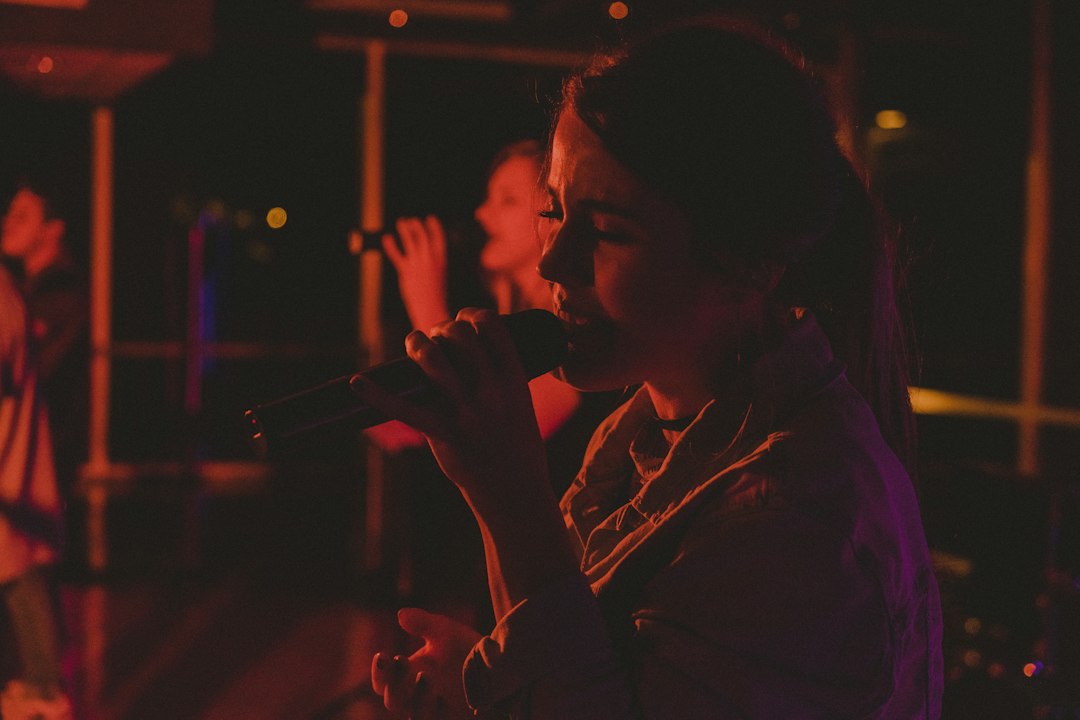 Two women singing together into microphones at a karaoke event